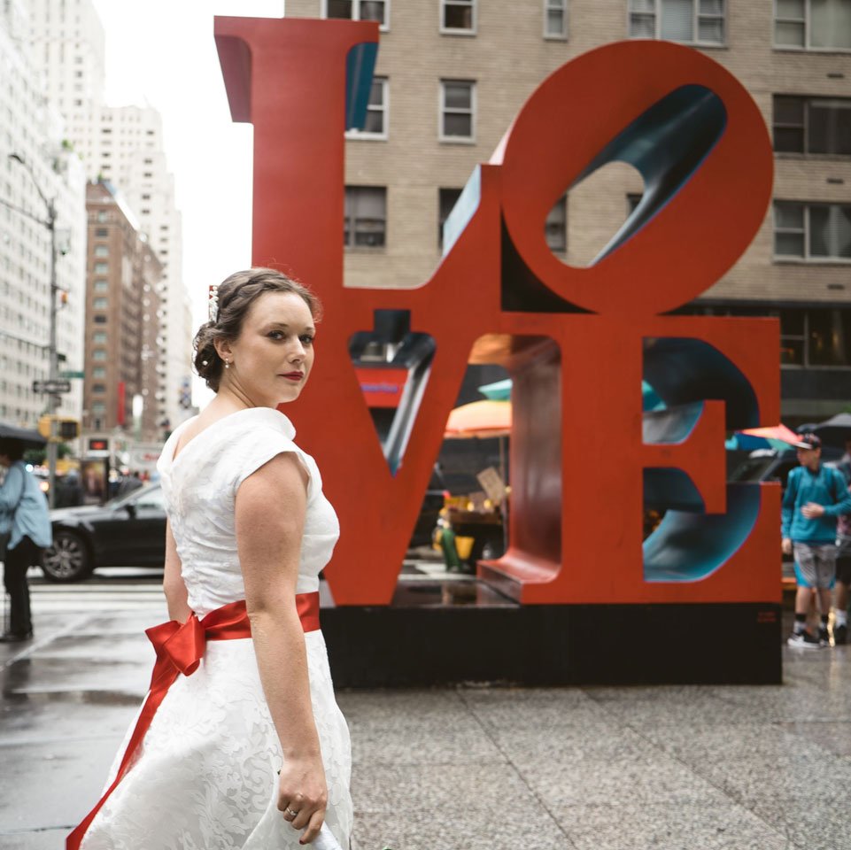 Photo of a bride by Love sign in Manhattan