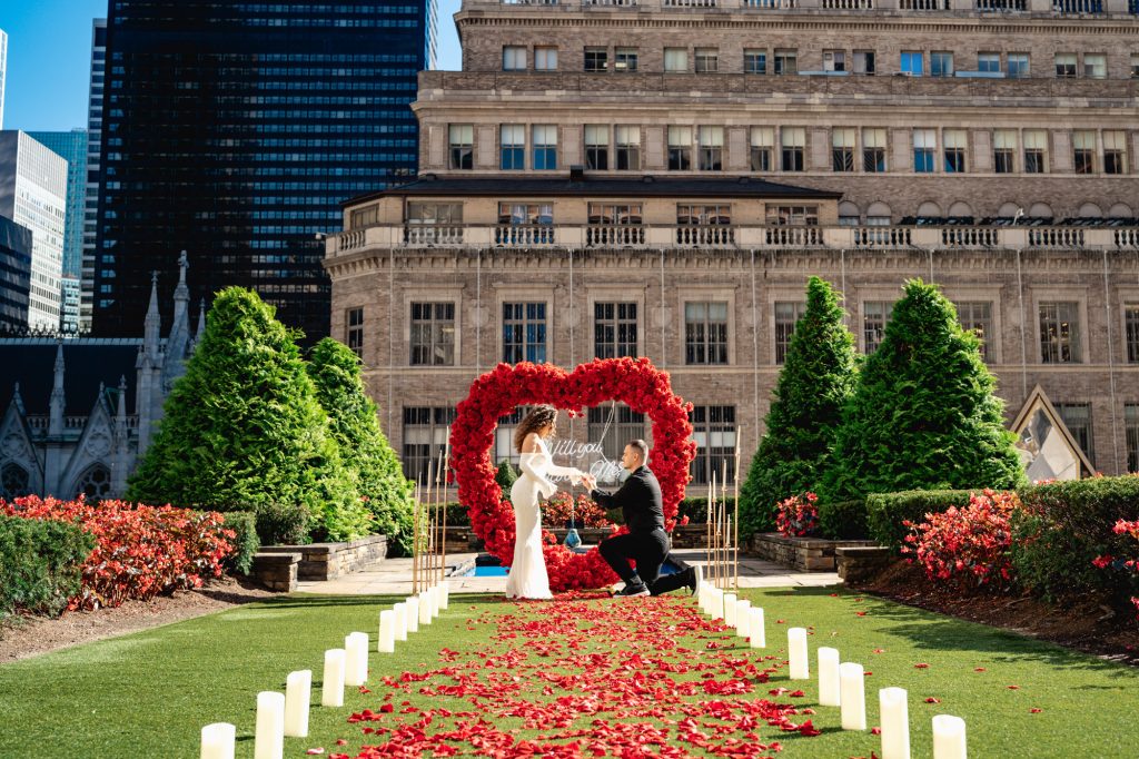 Proposal at 620 Loft & Garden: a red rose heart at the end of a petal aisle lined with candles