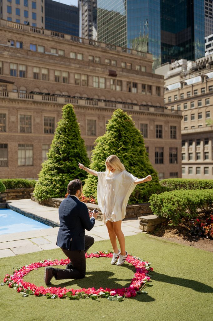 Proposal at 620 Loft & Garden, New York, inside a heart of pink petals on the rooftop lawn