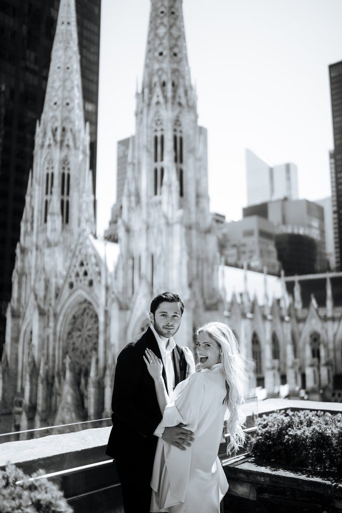 Black and white engagement portrait at 620 Loft & Garden with St. Patrick's Cathedral behind