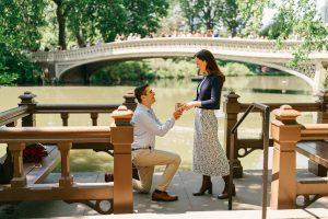 Surprise proposal in front of Bow Bridge in Central Park, New York, photographed from the boat landing
