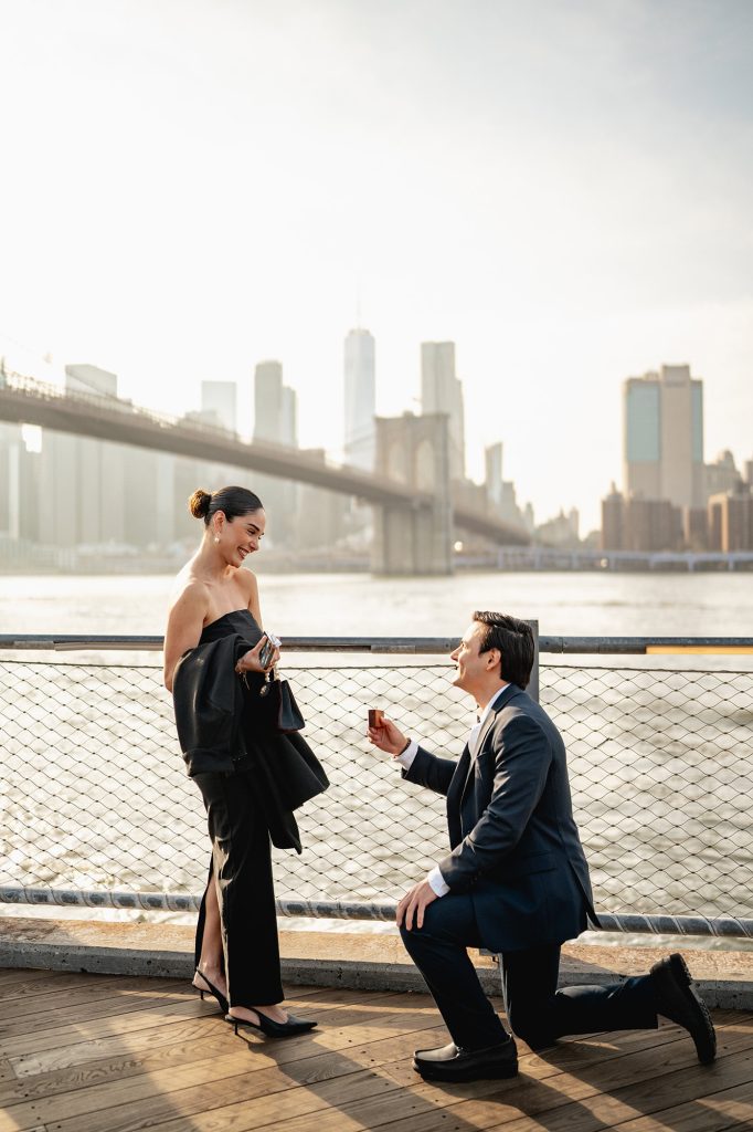Surprise proposal at Brooklyn Bridge Park in DUMBO with the Manhattan skyline across the East River