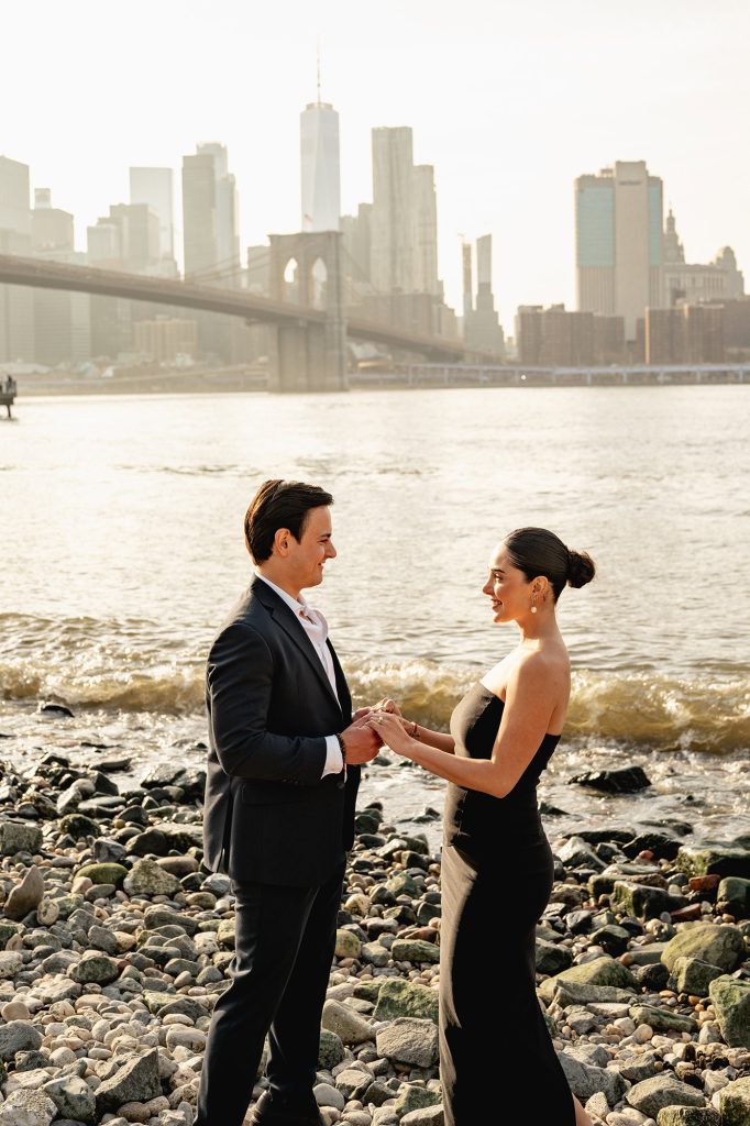 Proposal on the rocks at Brooklyn Bridge Park with the Manhattan skyline across the water