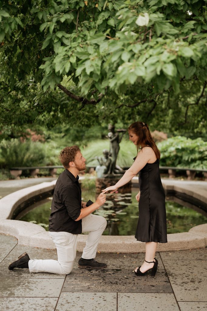 Surprise proposal beside the fountain at the Conservatory Garden in Central Park, New York