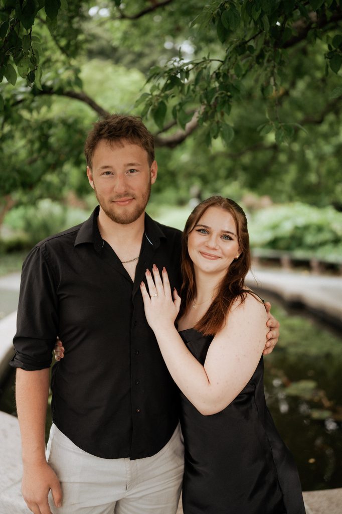 Newly engaged couple by the pond at the Conservatory Garden in Central Park, New York