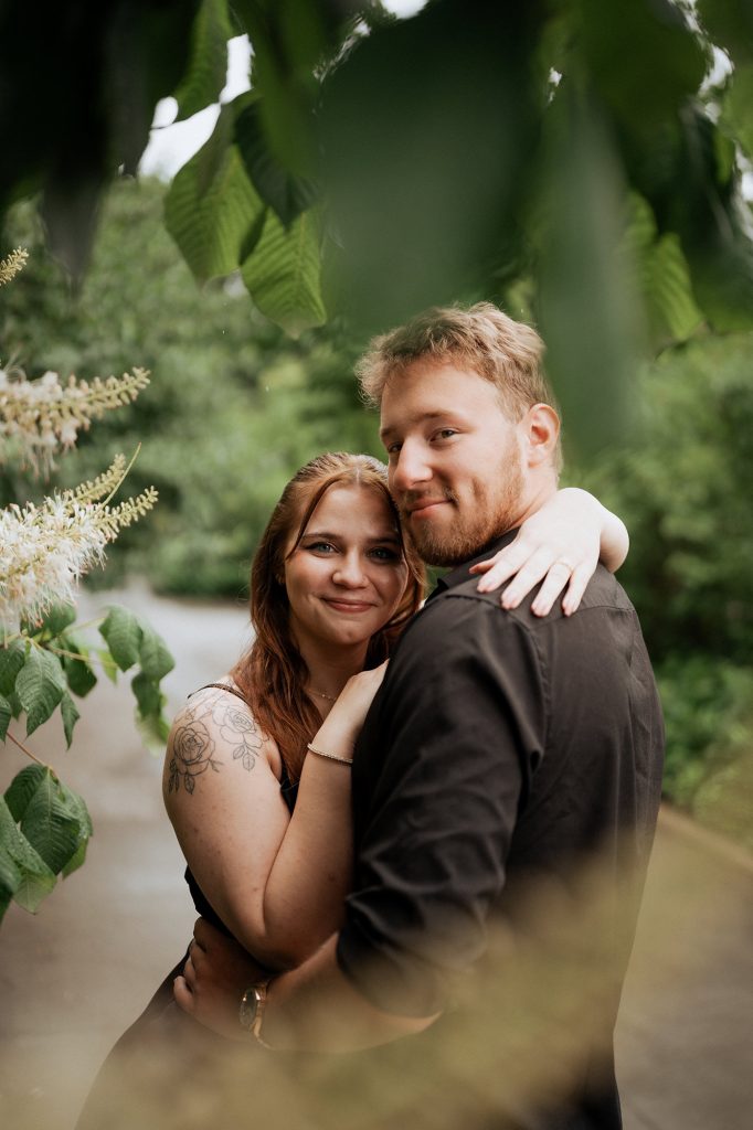 Newly engaged couple embracing among the greenery at the Conservatory Garden, Central Park