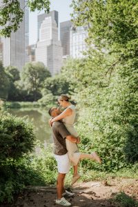 Man lifting his fiancee by the Lake in Central Park after a surprise proposal