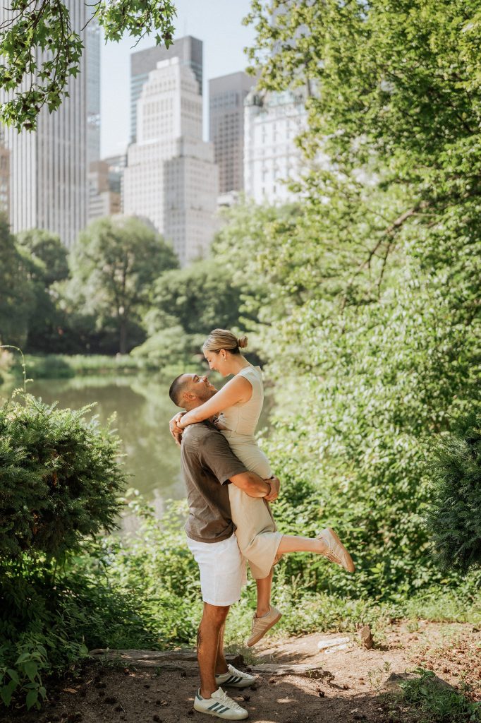 Man lifting his fiancee by the Lake in Central Park after a surprise proposal