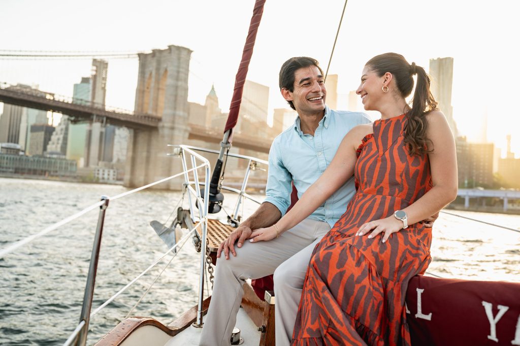 Engagement photos on a New York yacht at sunset with the Brooklyn Bridge behind