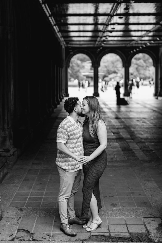 Black and white engagement portrait under the Bethesda Arcade in Central Park, New York