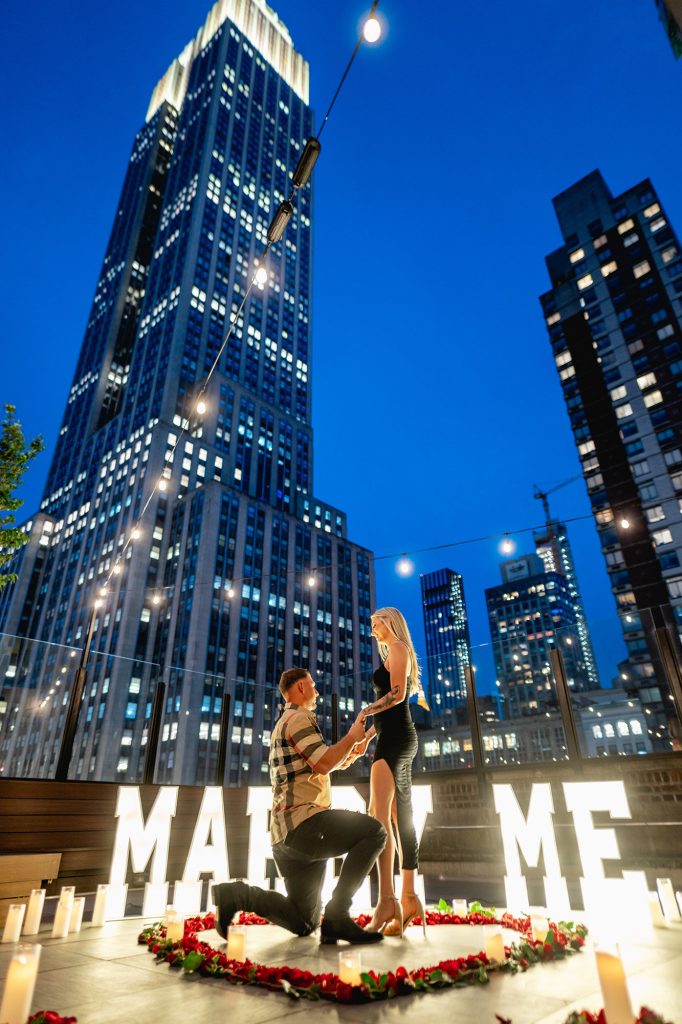 Blue hour proposal at Sparkling Midtown Rooftop in Manhattan with lit MARRY ME letters and a rose heart