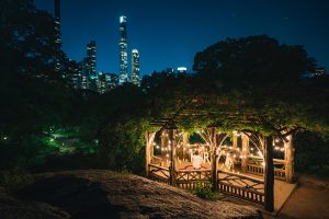 Summerhouse at the Dene, Central Park lit with candles for a surprise proposal, Midtown skyline behind the trees