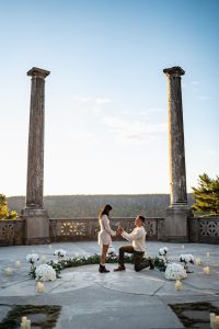 Autumn proposal at Untermyer Gardens: man on one knee between the two columns of the overlook, flowers laid in a circle, the Hudson beyond
